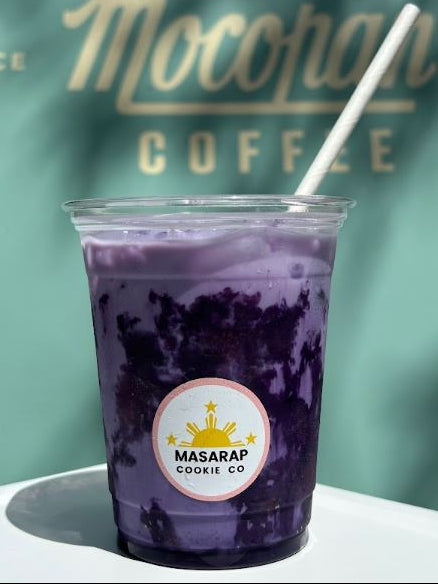 Purple iced drink in a clear cup with a straw, branded 'Moccamain Coffee' and 'Masarap Cookie Co.'